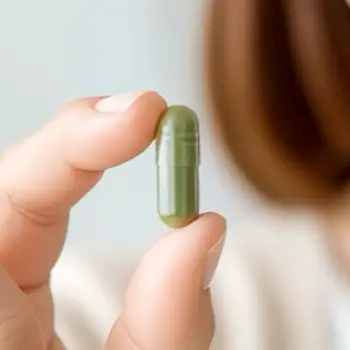 Woman holding a capsule of Telo-Vital